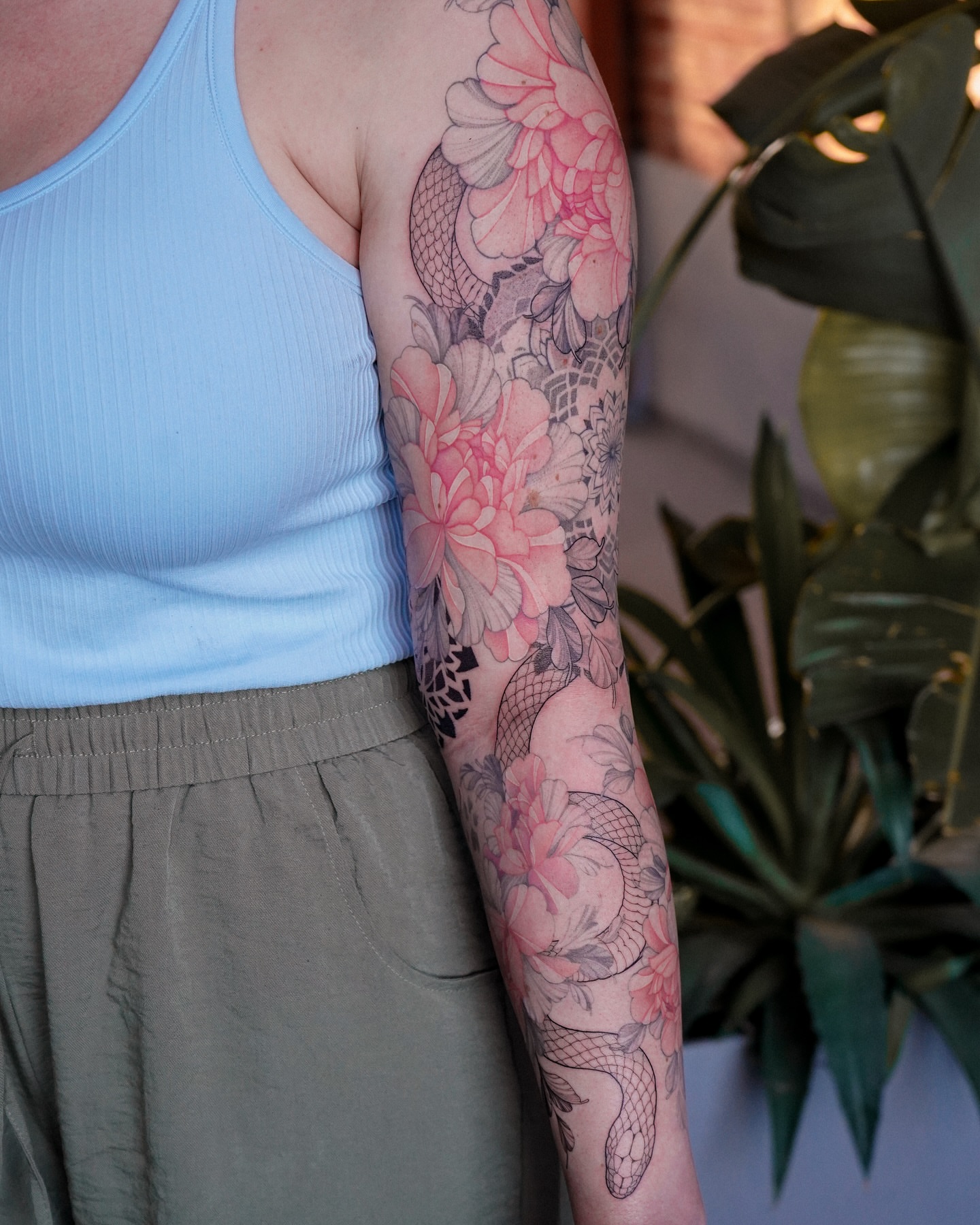 Floral and snake new school tattoo on the forearm by Flower Tattoo Sf