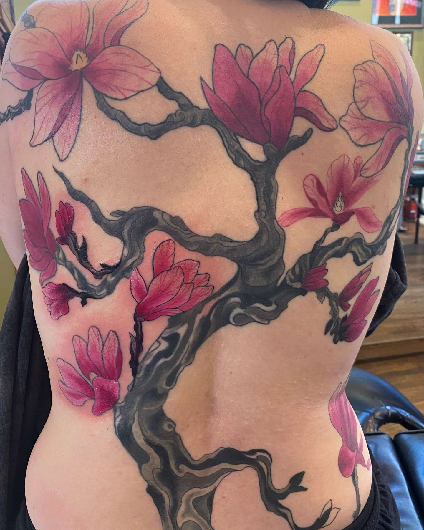 Magnolia blossoms realism tattoo on the back by Vyvyn Lazonga
