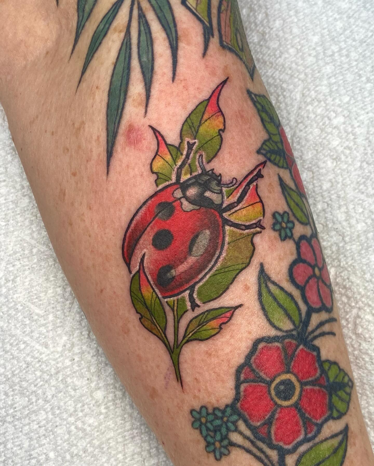 Ladybug and flowers American traditional tattoo on the forearm by ππππππ