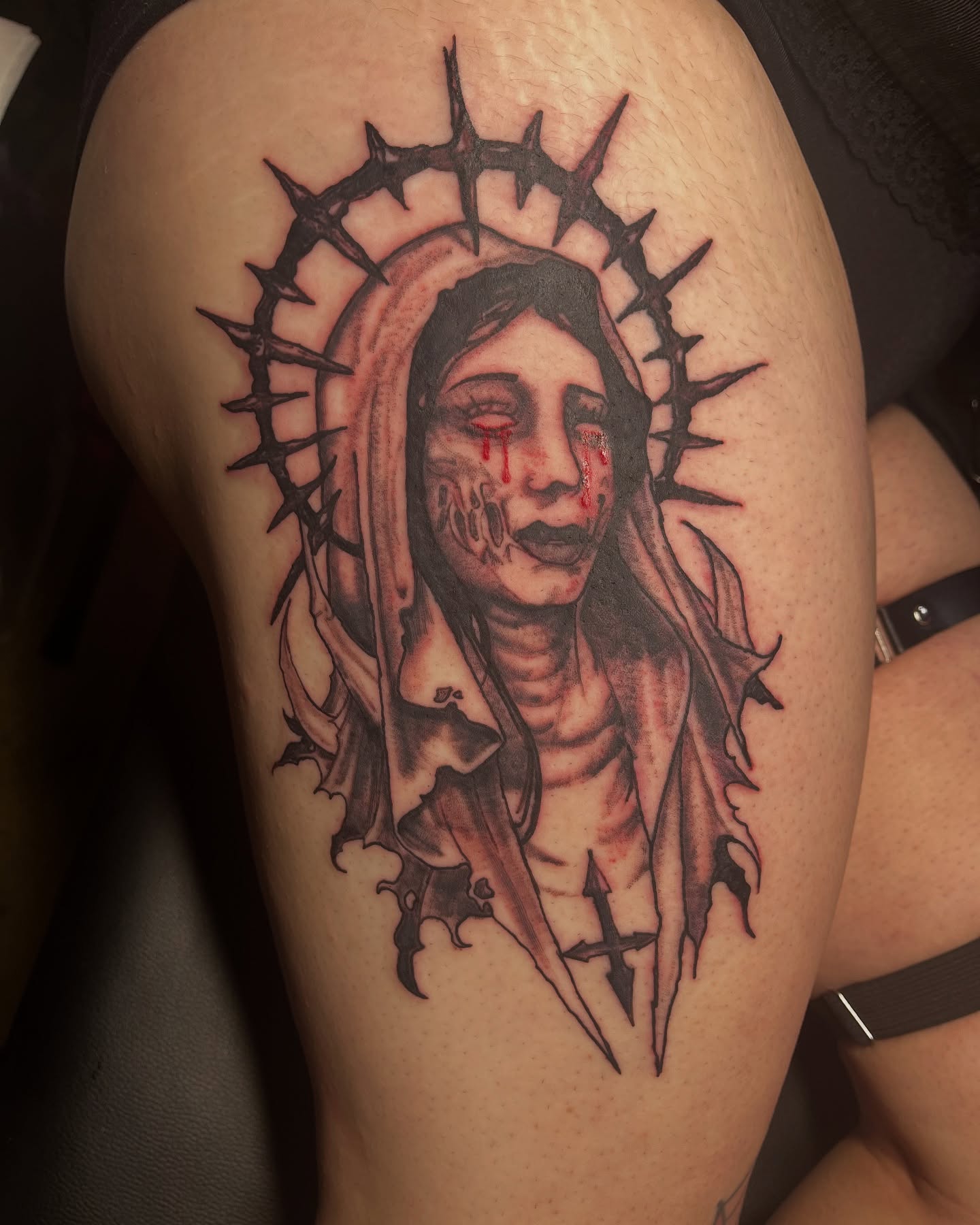 Religious figure dark realism tattoo on the thigh by Eddie Cesena