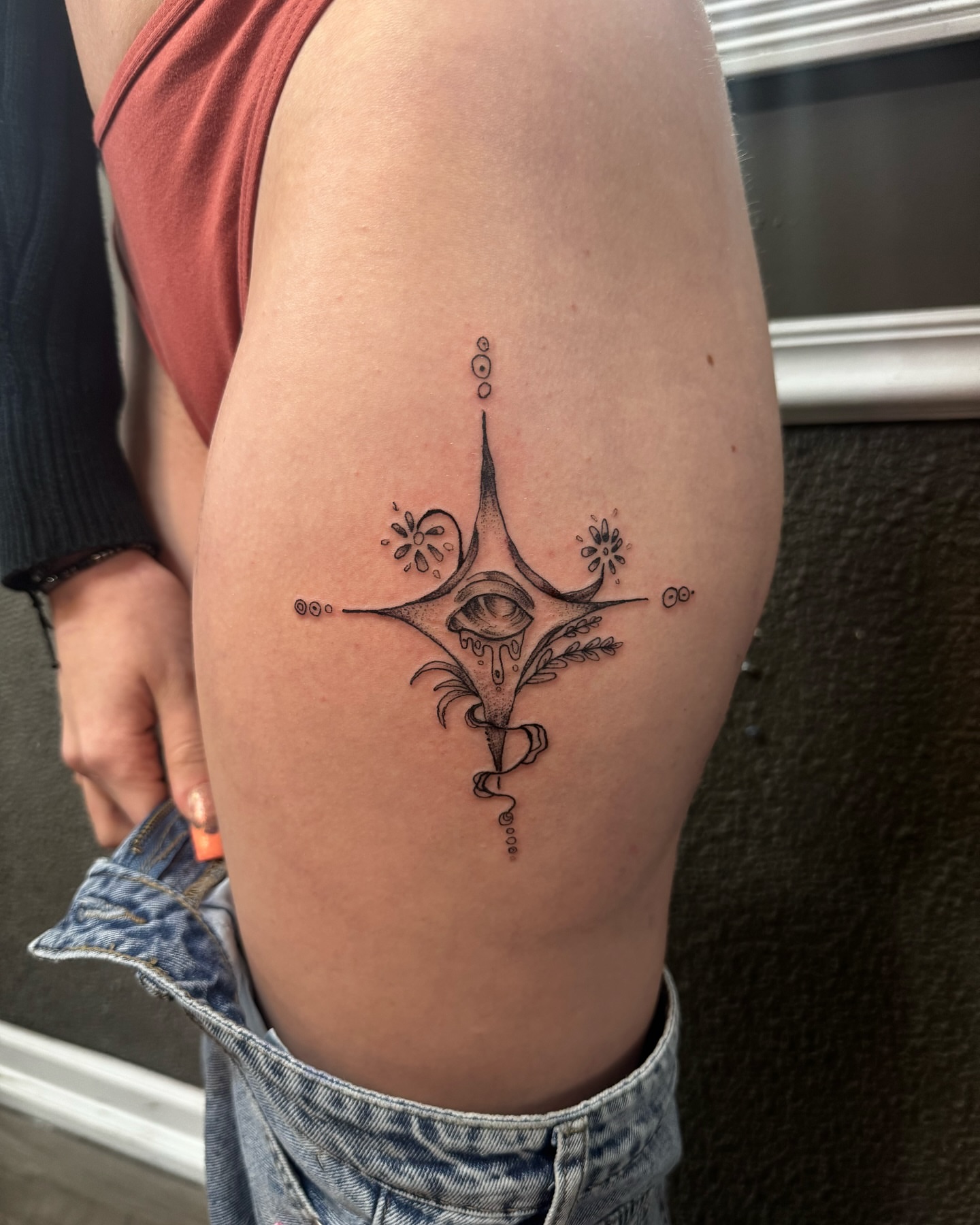Eye with floral elements geometric tattoo on the thigh by Lexy