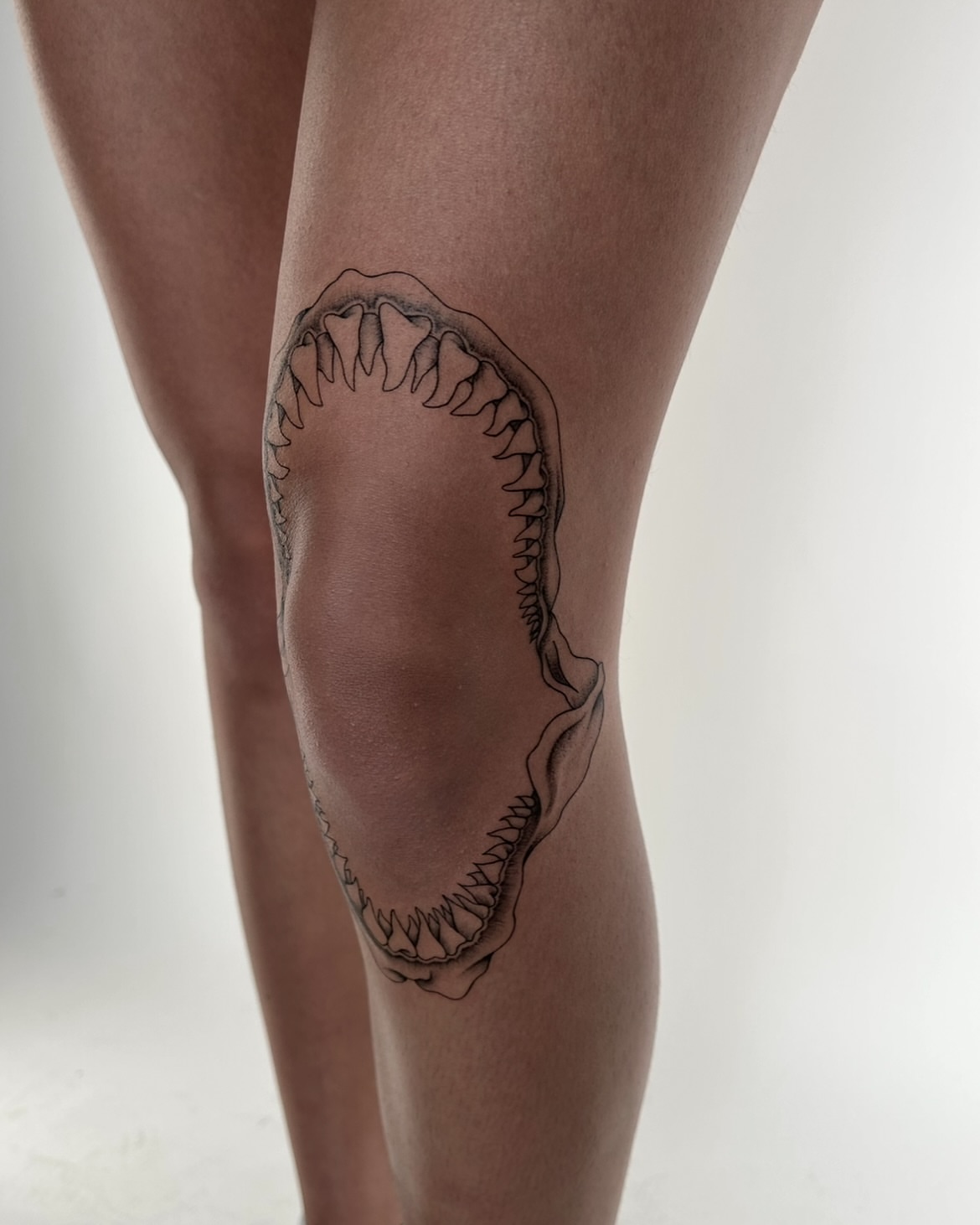 Jaws black and grey tattoo on the thigh by Kennedy Ramey