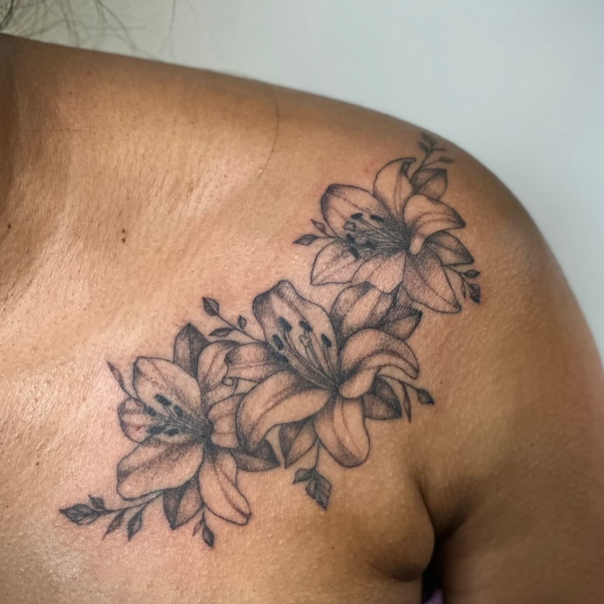 Lilies black and grey tattoo on the shoulder by Bell