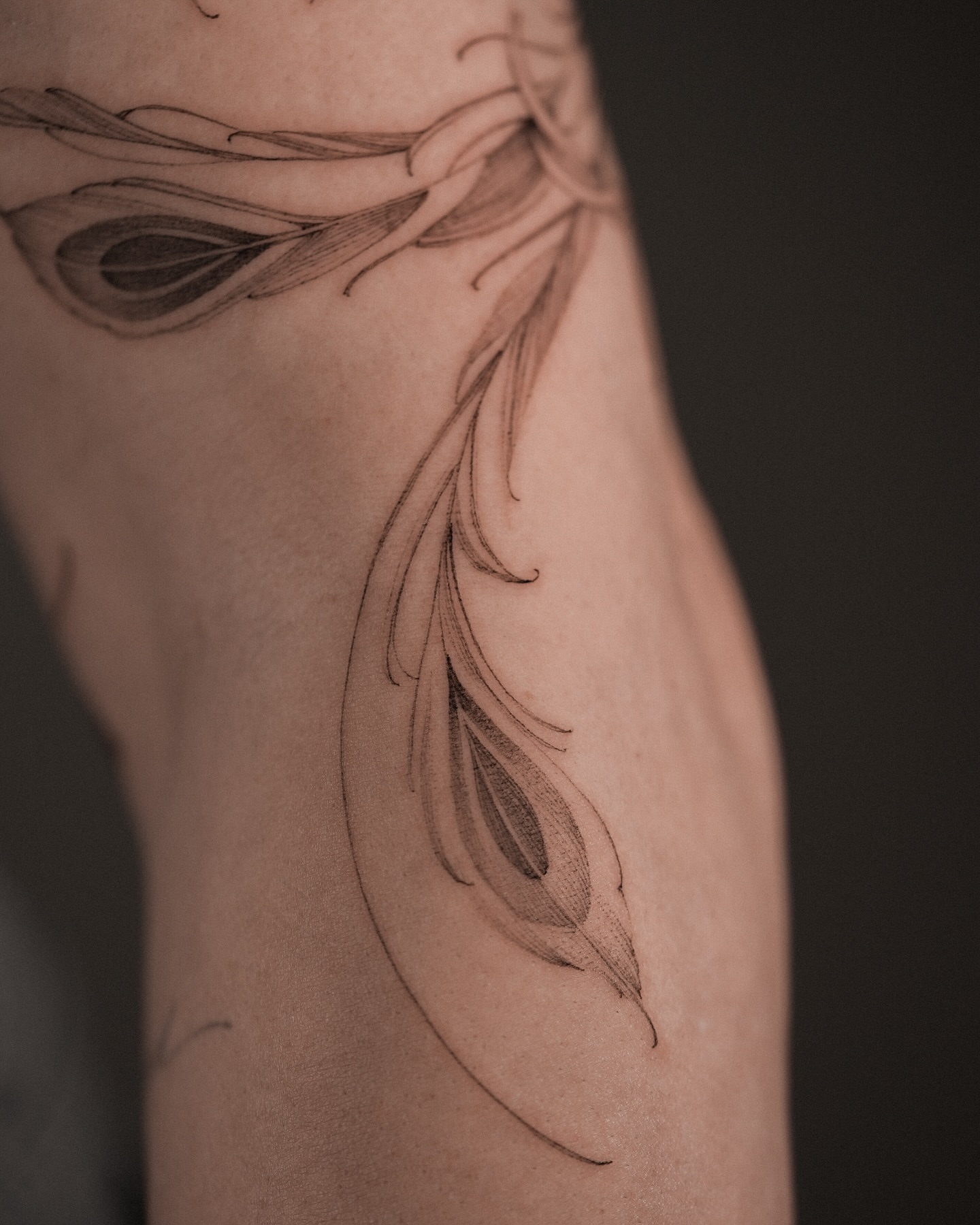 Feather black and grey tattoo on the forearm by Mary Shekh