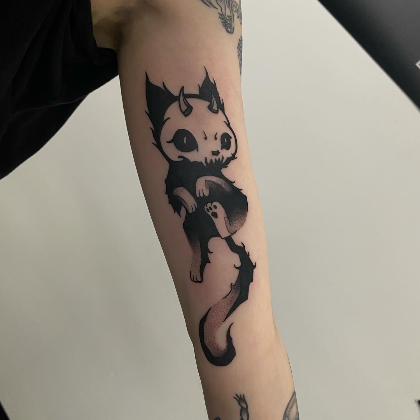 Cat black and grey tattoo on the forearm by Romans