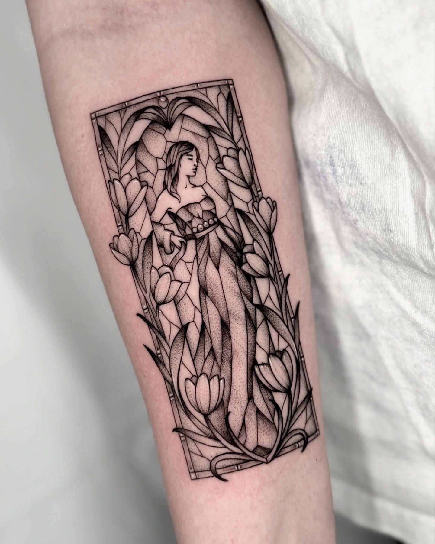Woman with flowers dotwork tattoo on the forearm by Kathryn Semus