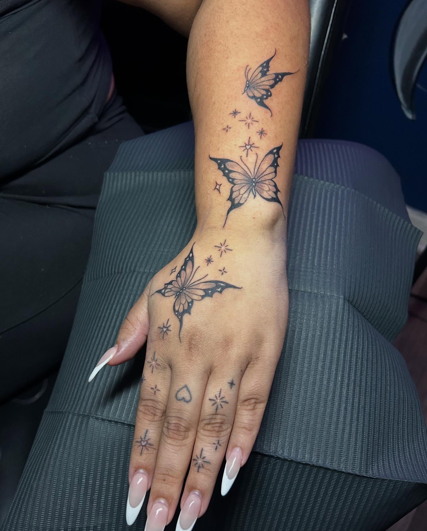 Butterflies black and grey tattoo on the hand by Kells