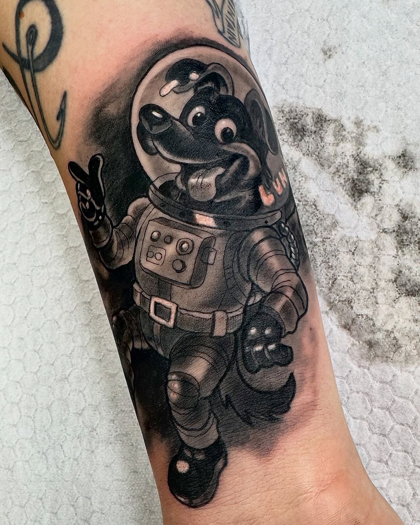 Astronaut dog realism tattoo on the forearm by Bacon 🥓