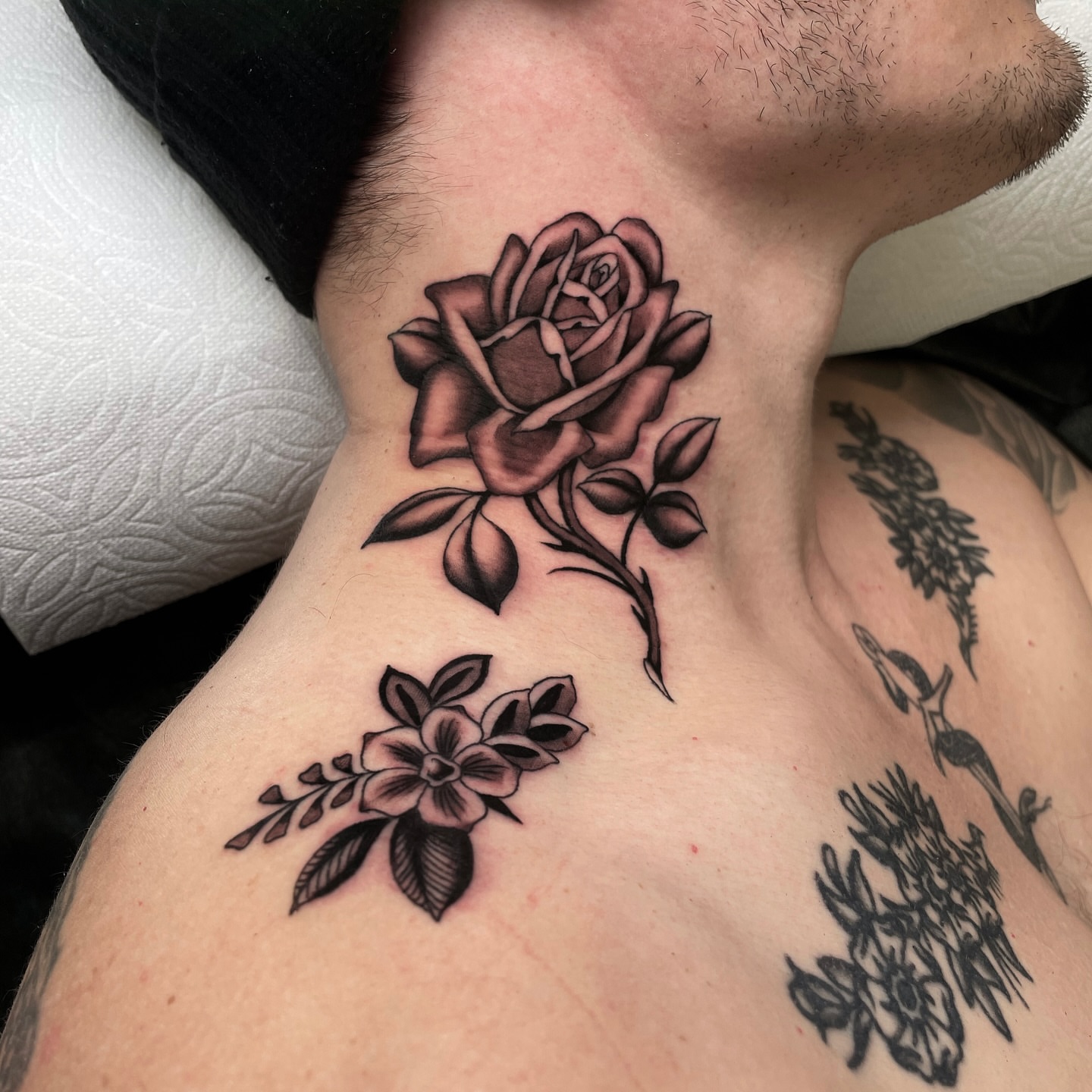 Rose and flowers black and grey tattoo on the chest by Niko Mulhearn