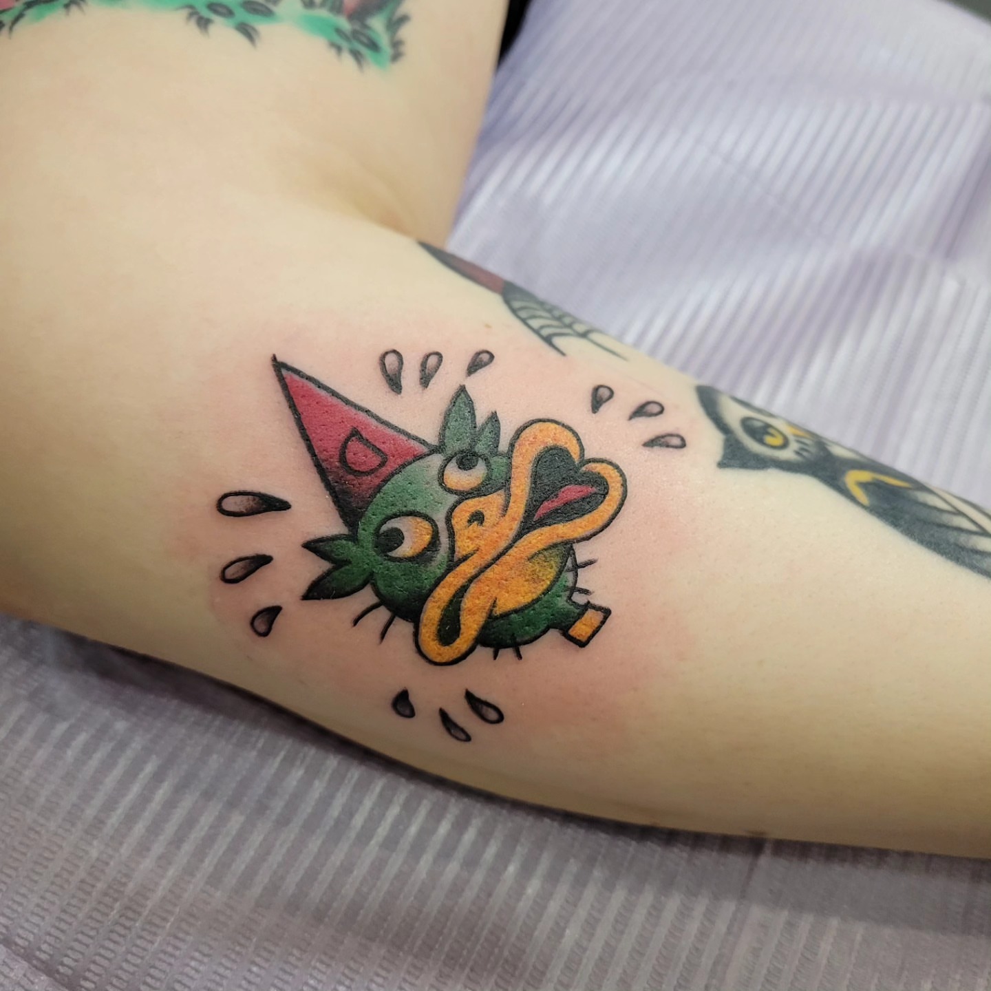 Party hat frog American traditional tattoo on the forearm by Mark Harada, Hoboken, New Jersey