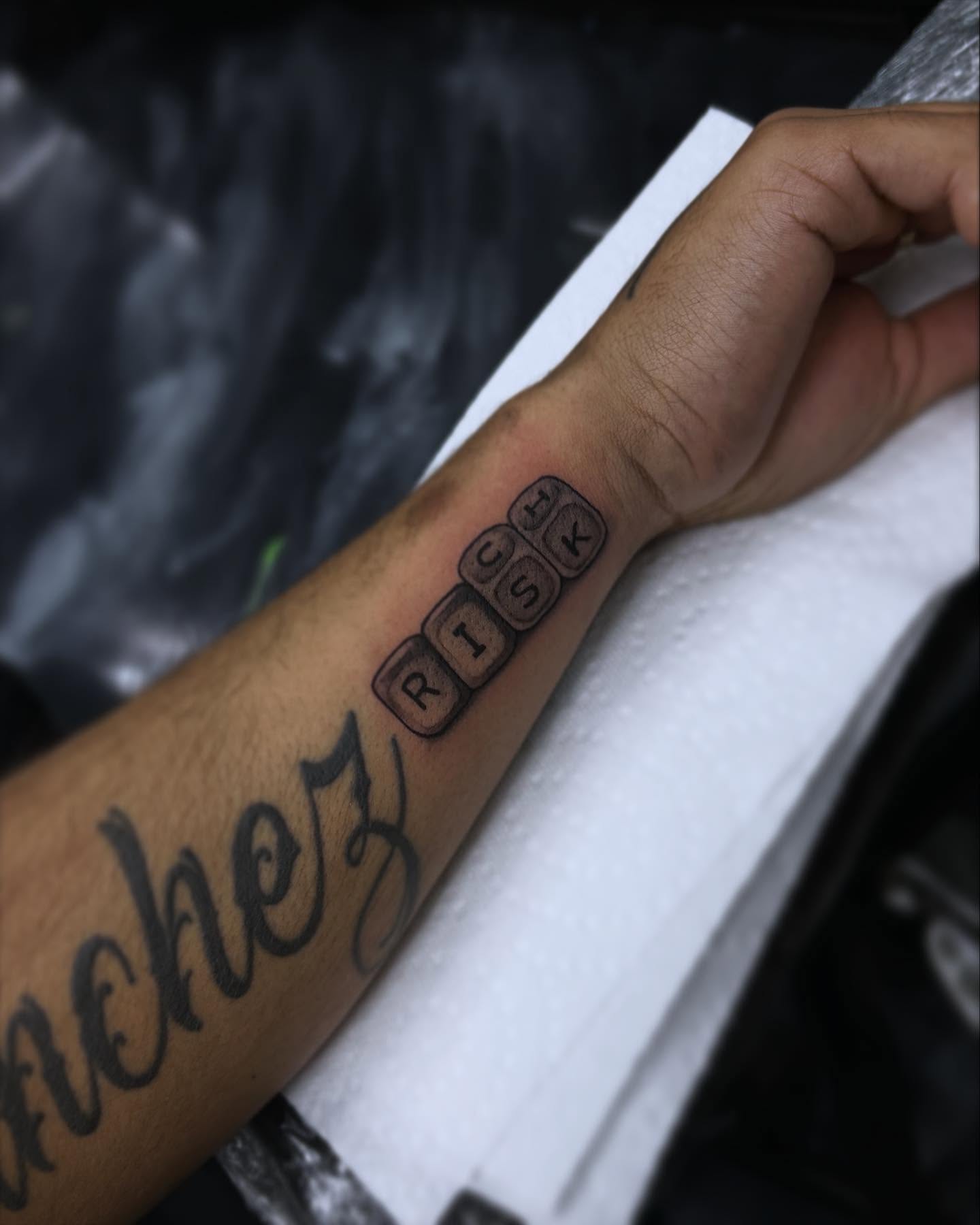 Risk lettering script tattoo on the forearm by 302inkgod, Wilmington, Delaware