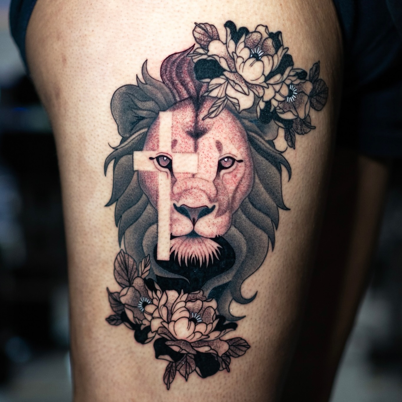 Lion with cross American traditional tattoo on the thigh by Jorden Ruppe