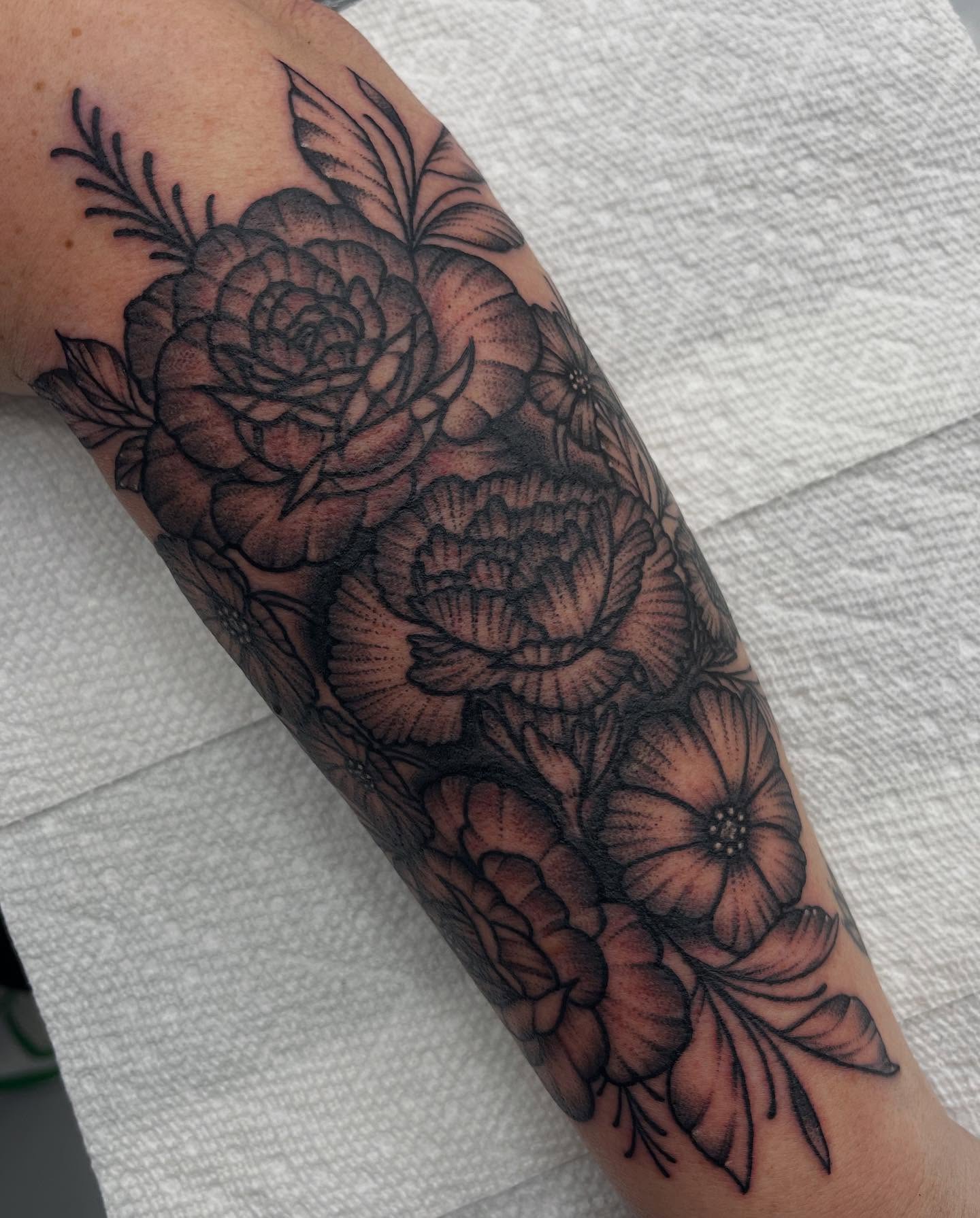 Floral bouquet black and grey tattoo on the forearm by Autumn Fulford