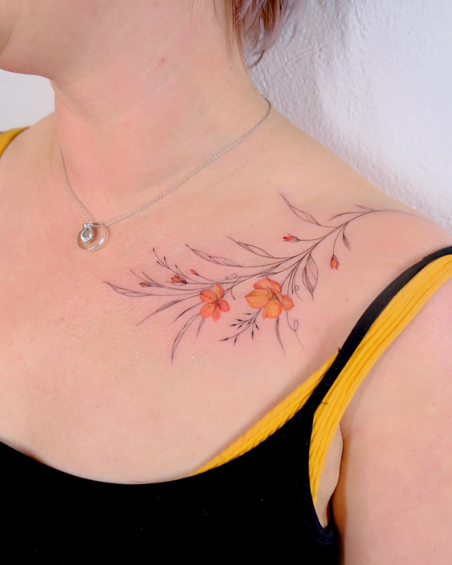 Floral branch watercolor tattoo on the chest by Thin line and color TATTOO.
