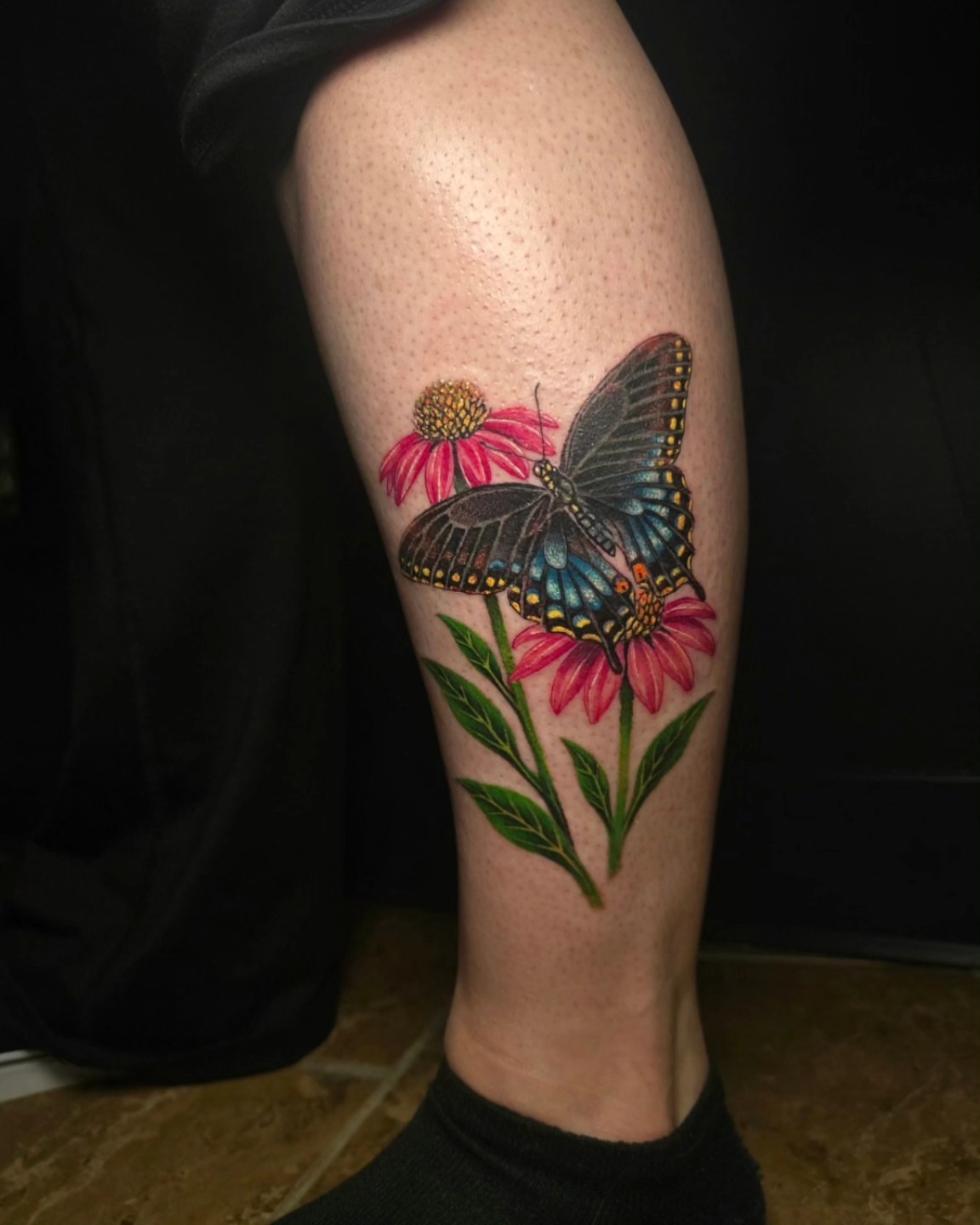 Butterfly and flowers realism tattoo on the thigh by Anna Brittany
