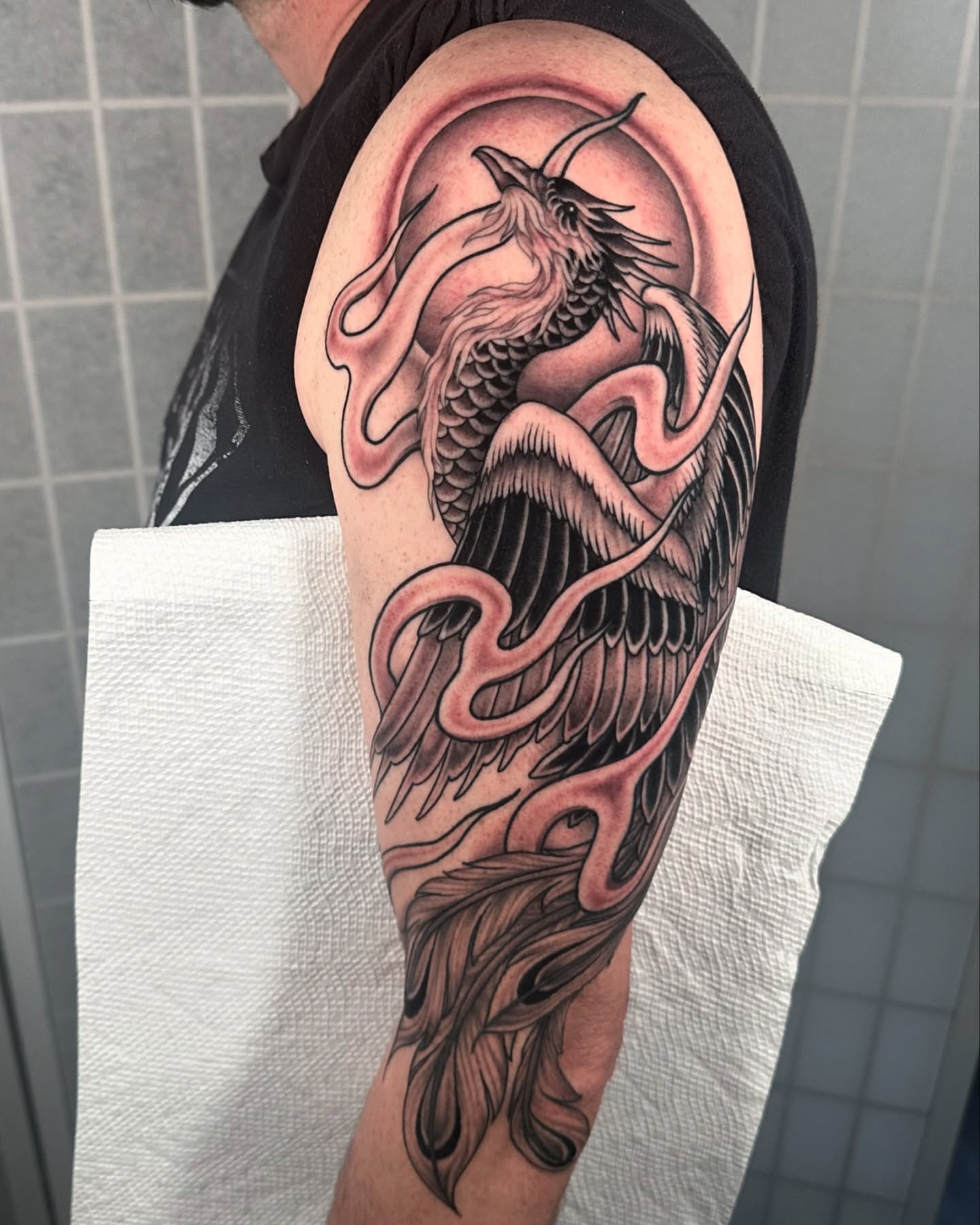 Phoenix black and grey tattoo on the forearm by Henry Gaßner