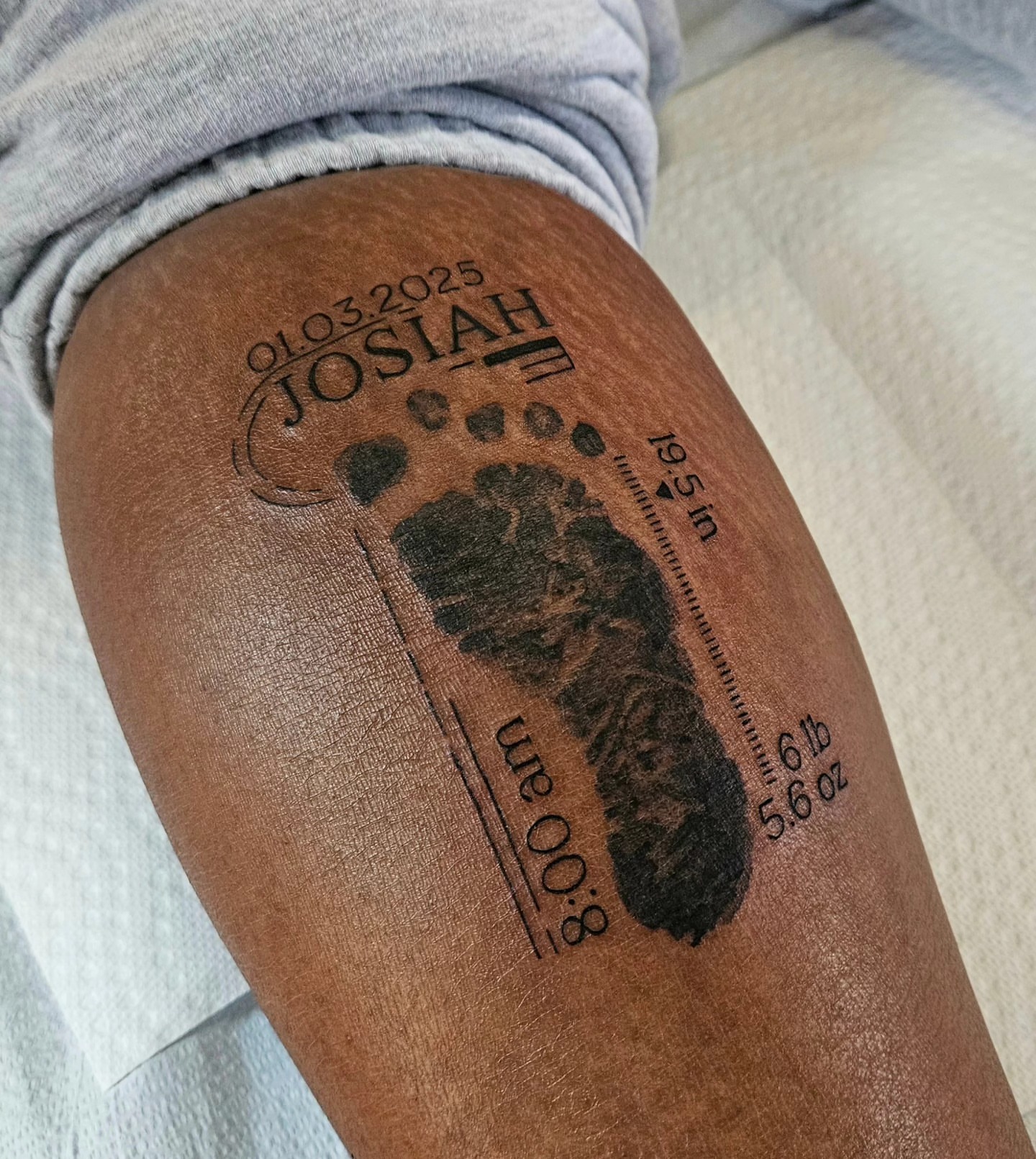 Baby footprint black and grey tattoo on the thigh by Chloe🌿Tattoos