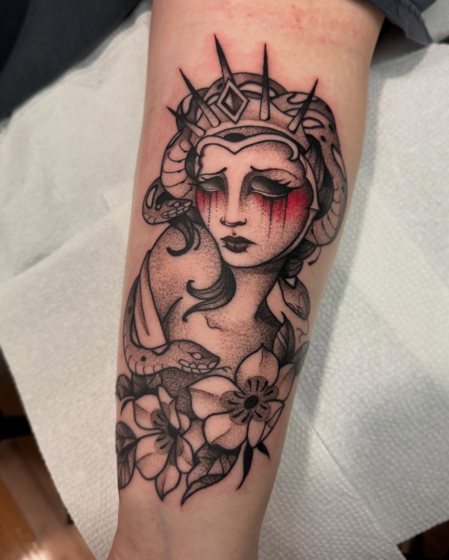 Woman with crown dotwork tattoo on the forearm by Lauren Peltz