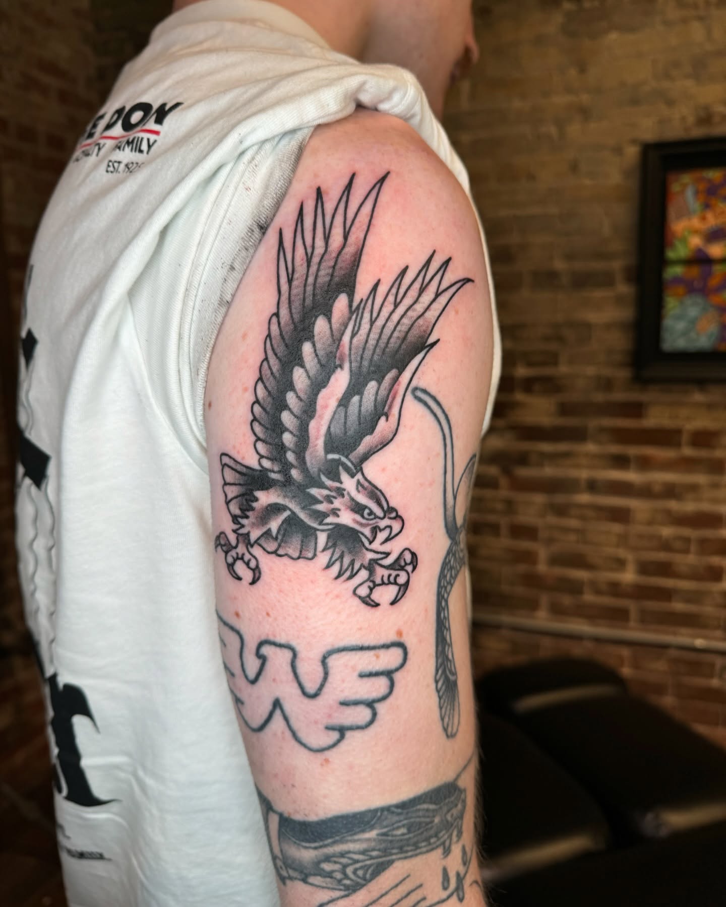Eagle black and grey tattoo on the upper arm by Marc Brotemarkle