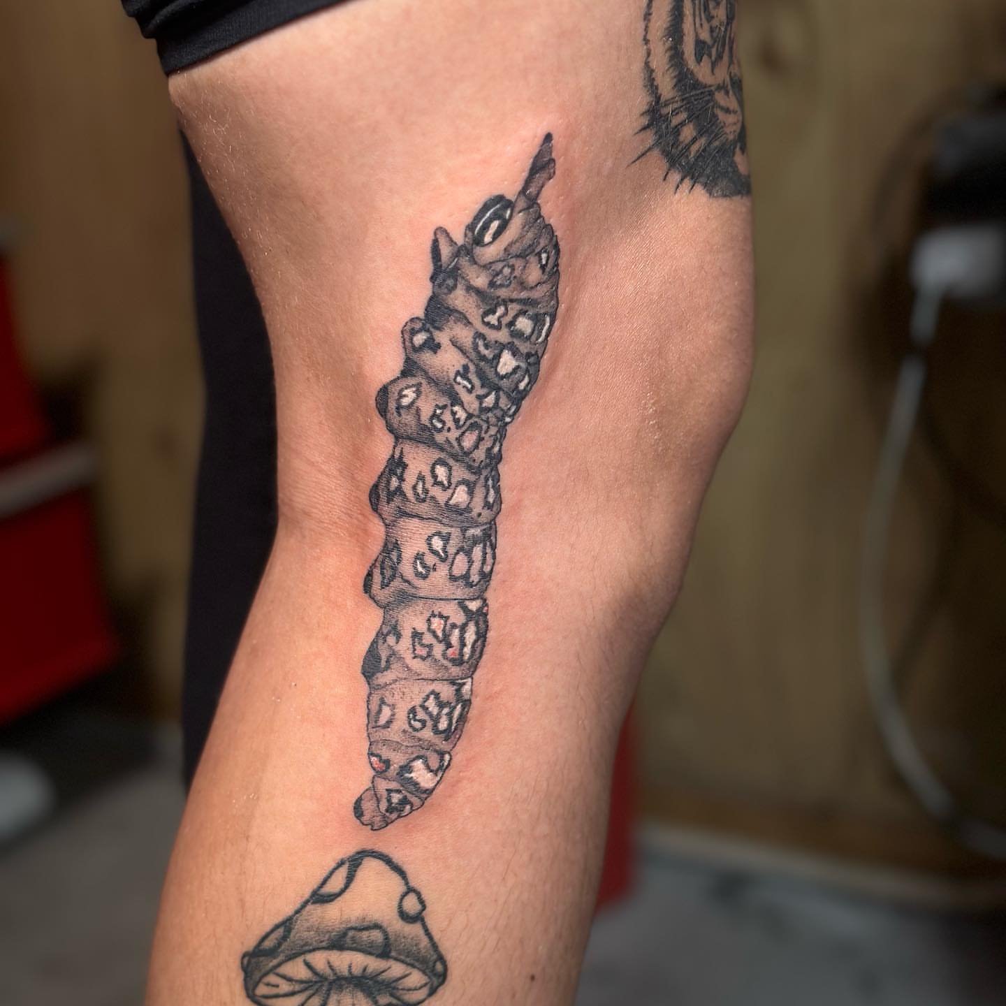 Worm black and grey tattoo on the thigh by Lee