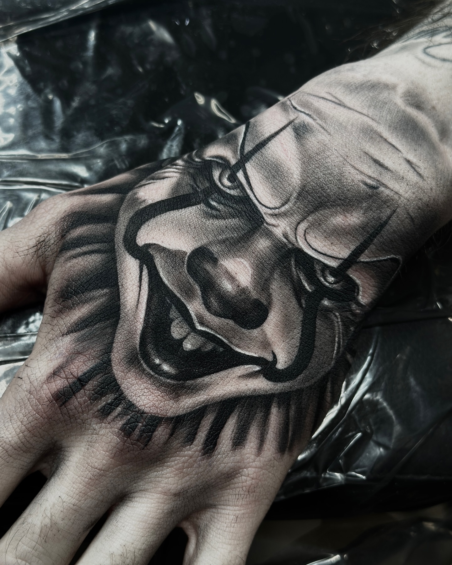 Clown face realism tattoo on the hand by Aaron Watson