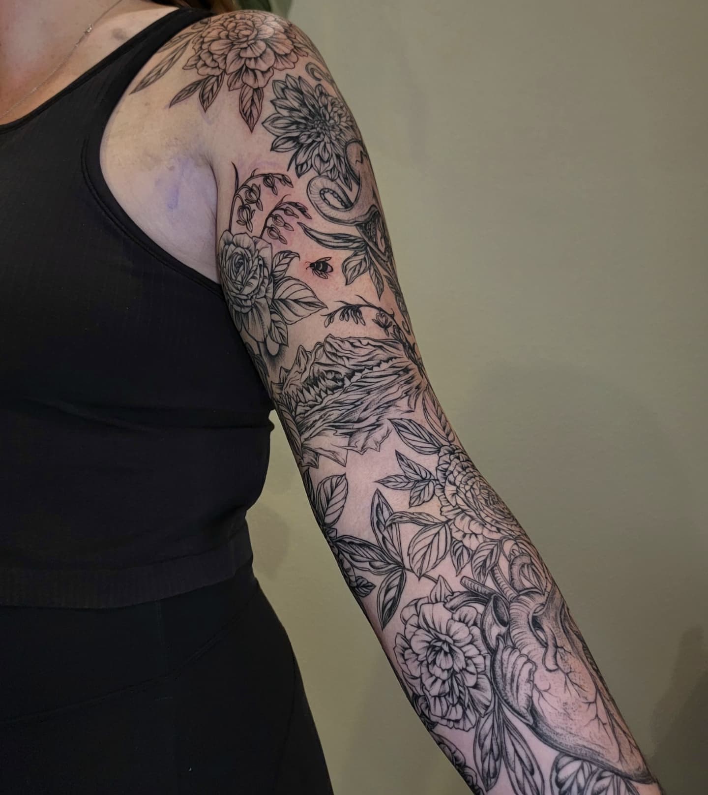 Floral and snake black and grey tattoo on the forearm by Sierra (cc) Klein