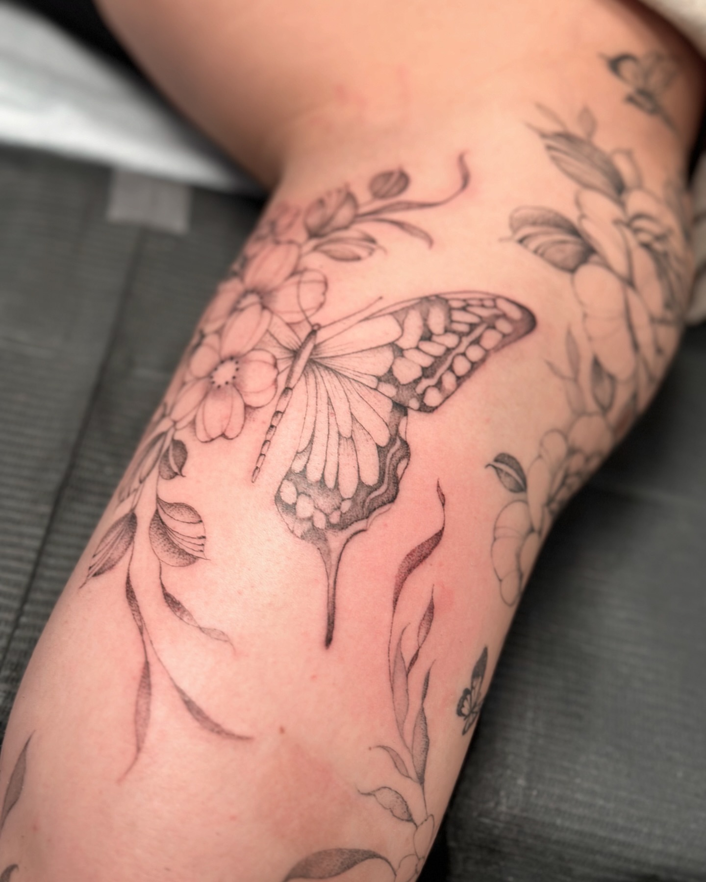 Butterfly and flowers black and grey tattoo on the forearm by ᴍɪᴄʜᴇʟʟᴇ, New York, New York