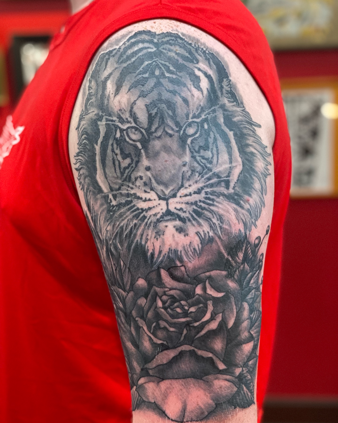 Tiger and rose realism tattoo on the upper arm by Christopher Sanders