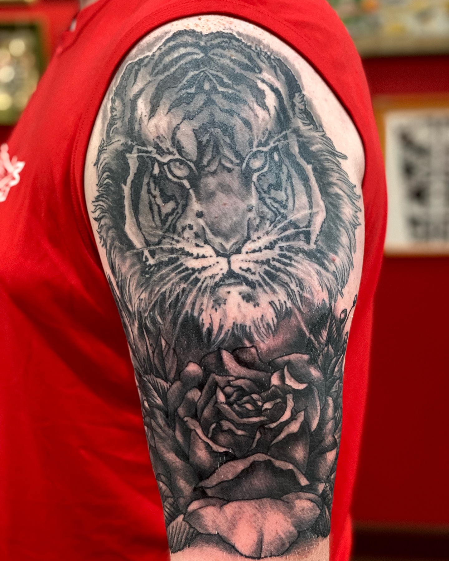 Tiger and rose realism tattoo on the upper arm by Christopher Sanders