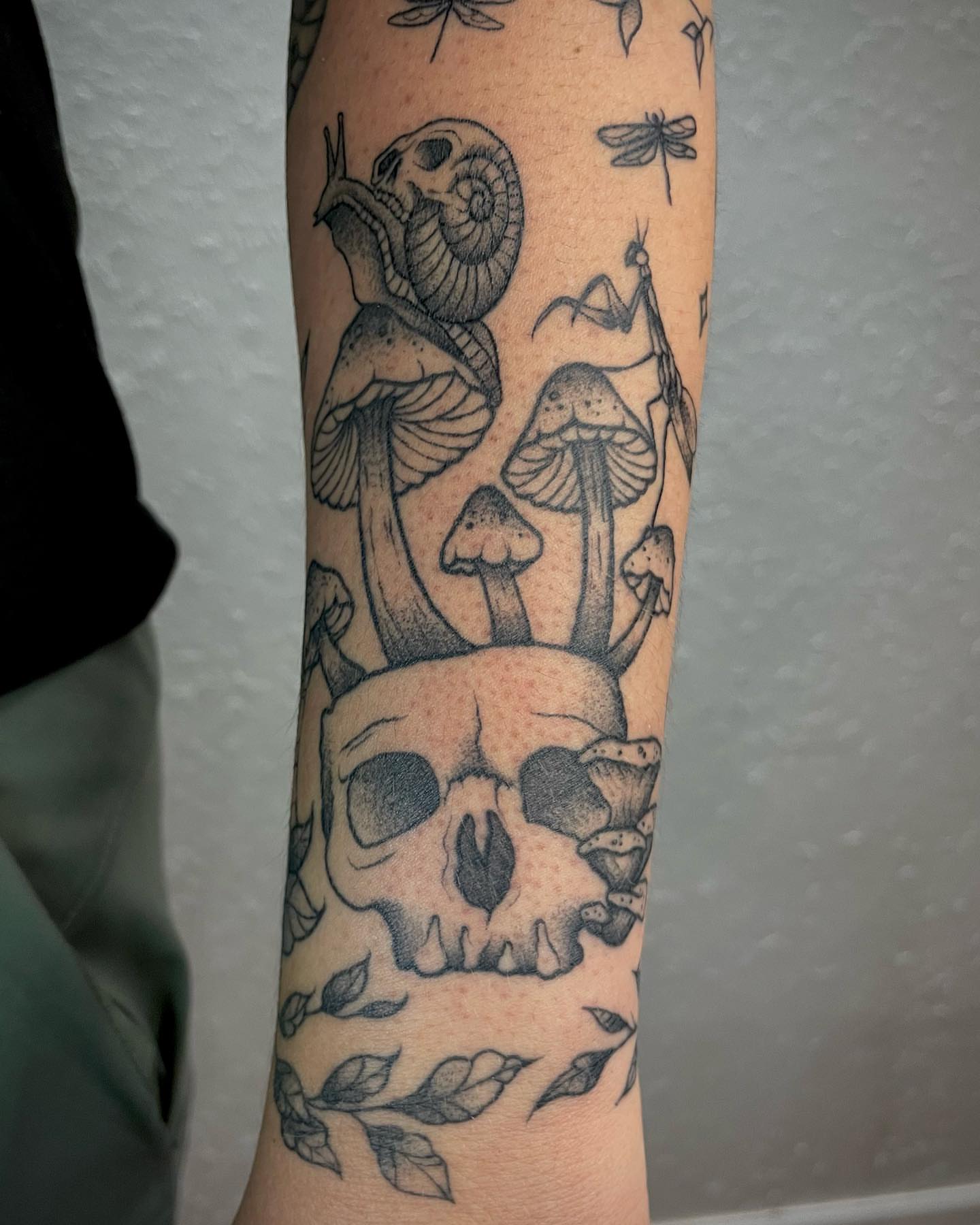 Skull and mushrooms dotwork tattoo on the forearm by Bryce Presley, Mission, Kansas