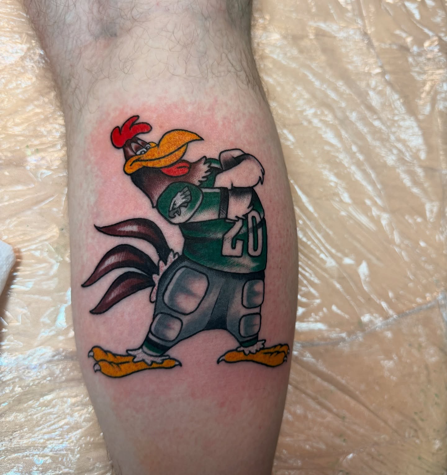 Football player American traditional tattoo on the forearm by Angus Perfect, Philadelphia, Pennsylvania