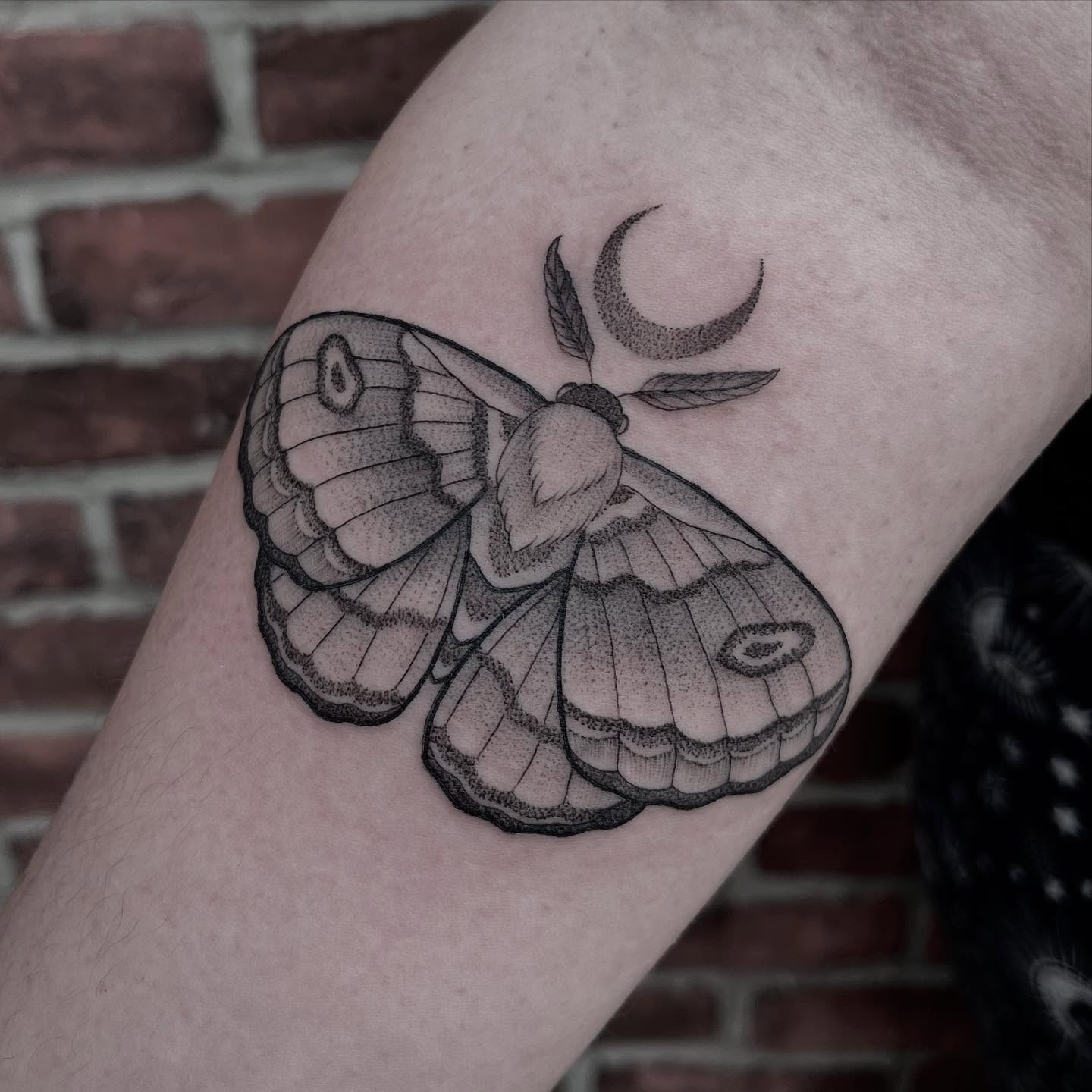 Moth and crescent moon dotwork tattoo on the forearm by Kat Ackerman