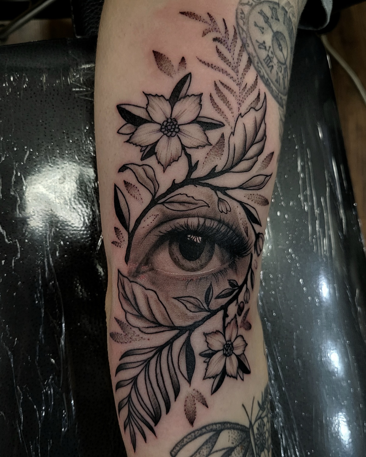 Eye with floral elements realism tattoo on the forearm by Douglas