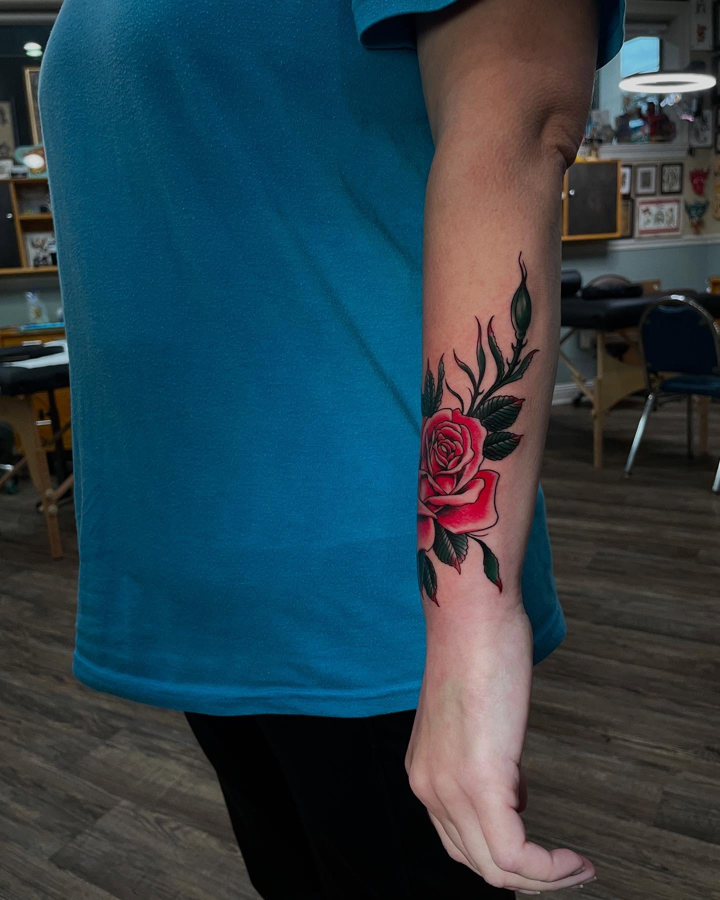 Rose American traditional tattoo on the forearm by Caleb Baker