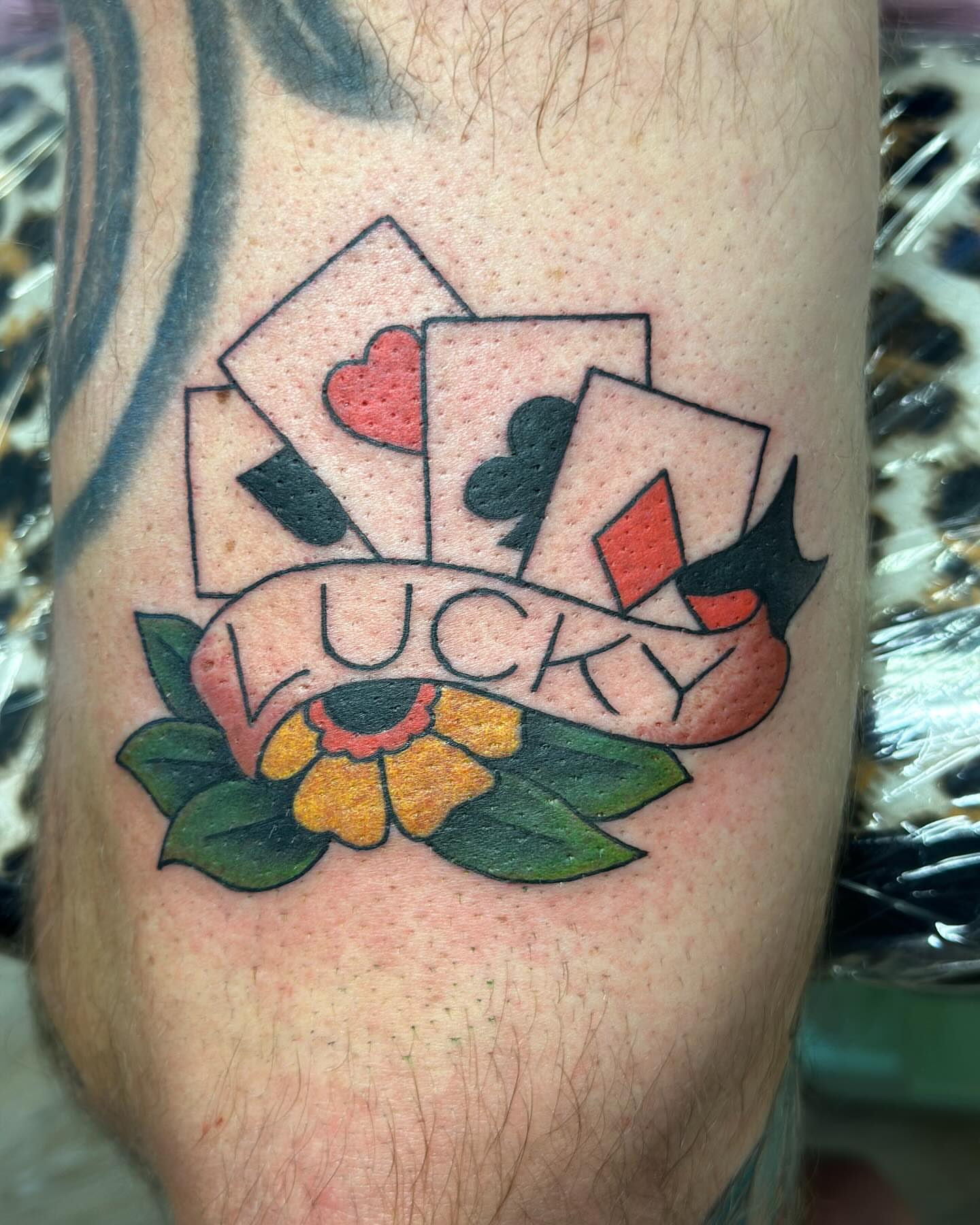 Playing cards and flower American traditional tattoo on the forearm by Classy Fucking Lady Tattooer