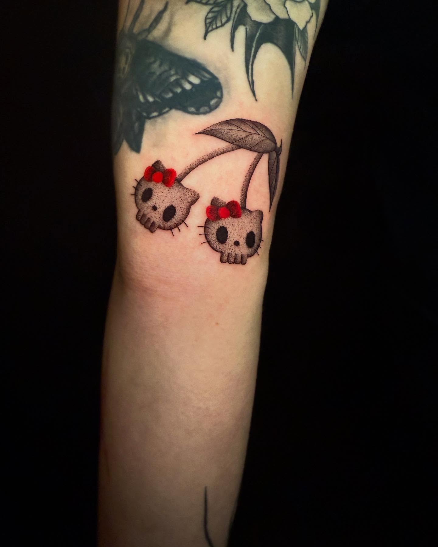 Hello Kitty black and grey tattoo on the forearm by Dylan Orbock, Berkeley, California