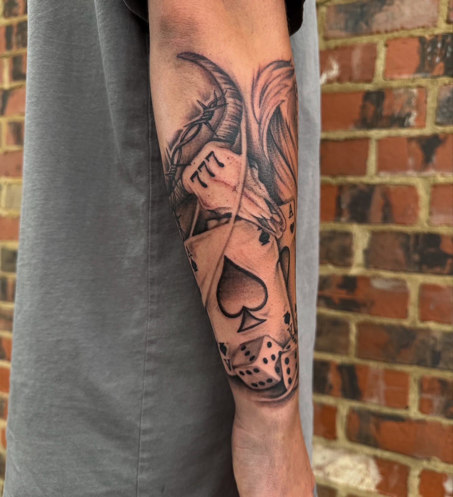 Playing card and dice realism tattoo on the forearm by Christian Hood
