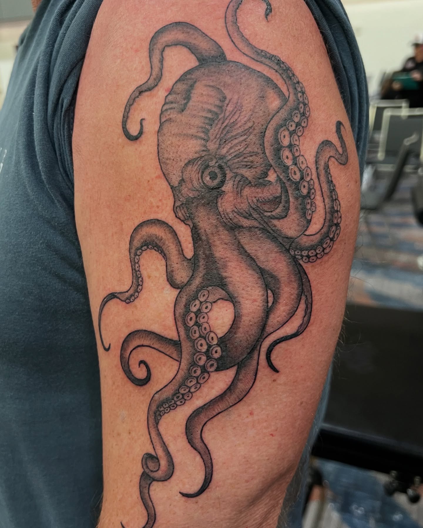 Octopus black and grey tattoo on the upper arm by Baung Ben