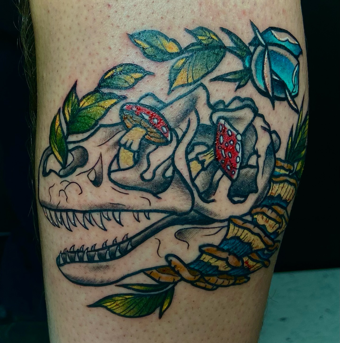 Dinosaur skull with mushrooms American traditional tattoo on the forearm by Vincent Figuccio