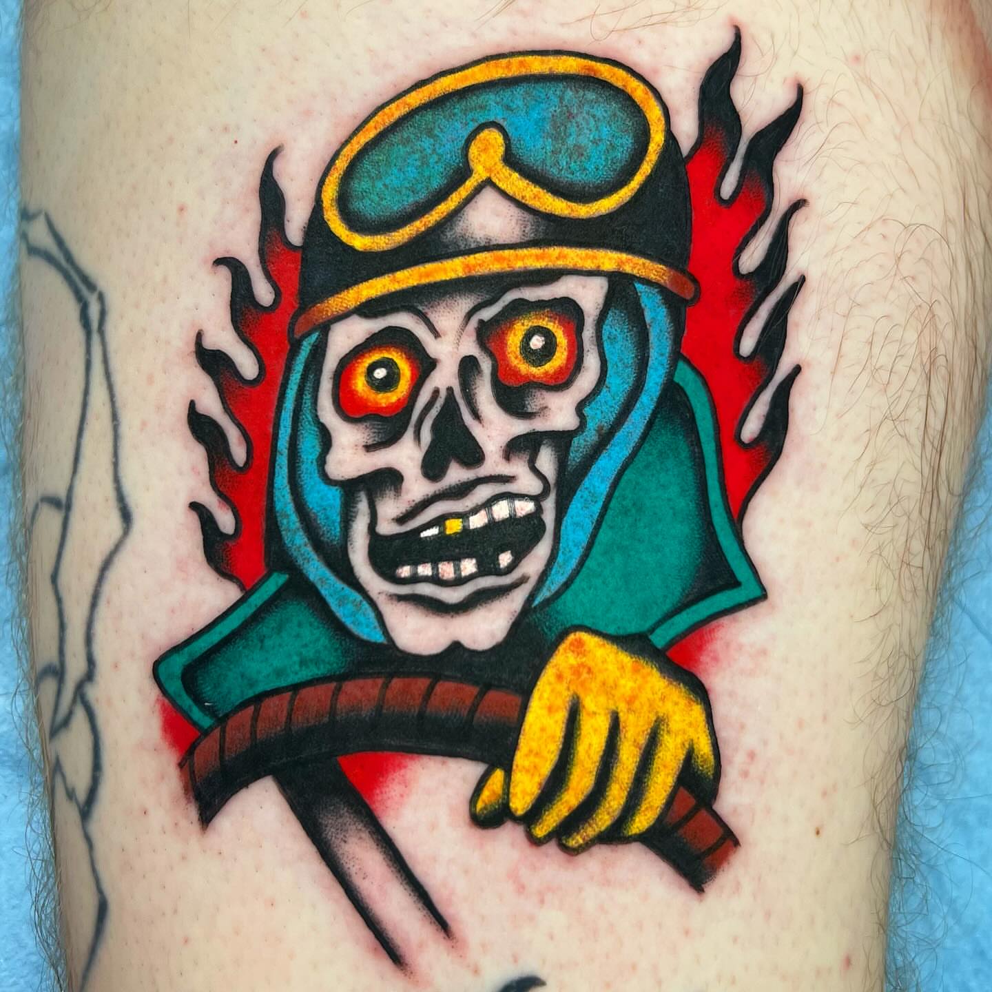 Skull wearing helmet American traditional tattoo on the forearm by Kevin Caruso