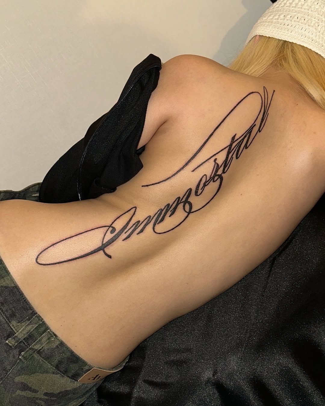 Script lettering 'Immortal' lettering tattoo on the back by eyeball