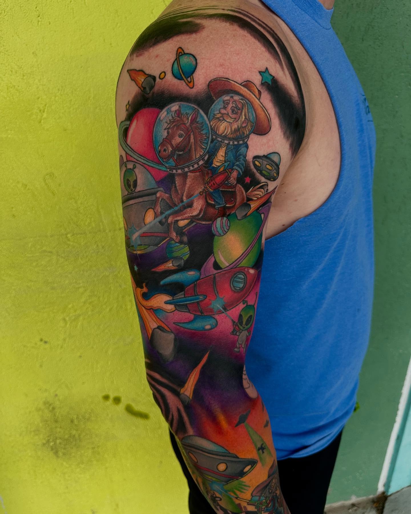 Space cowboy new school tattoo on the upper arm by Holle Hellfire