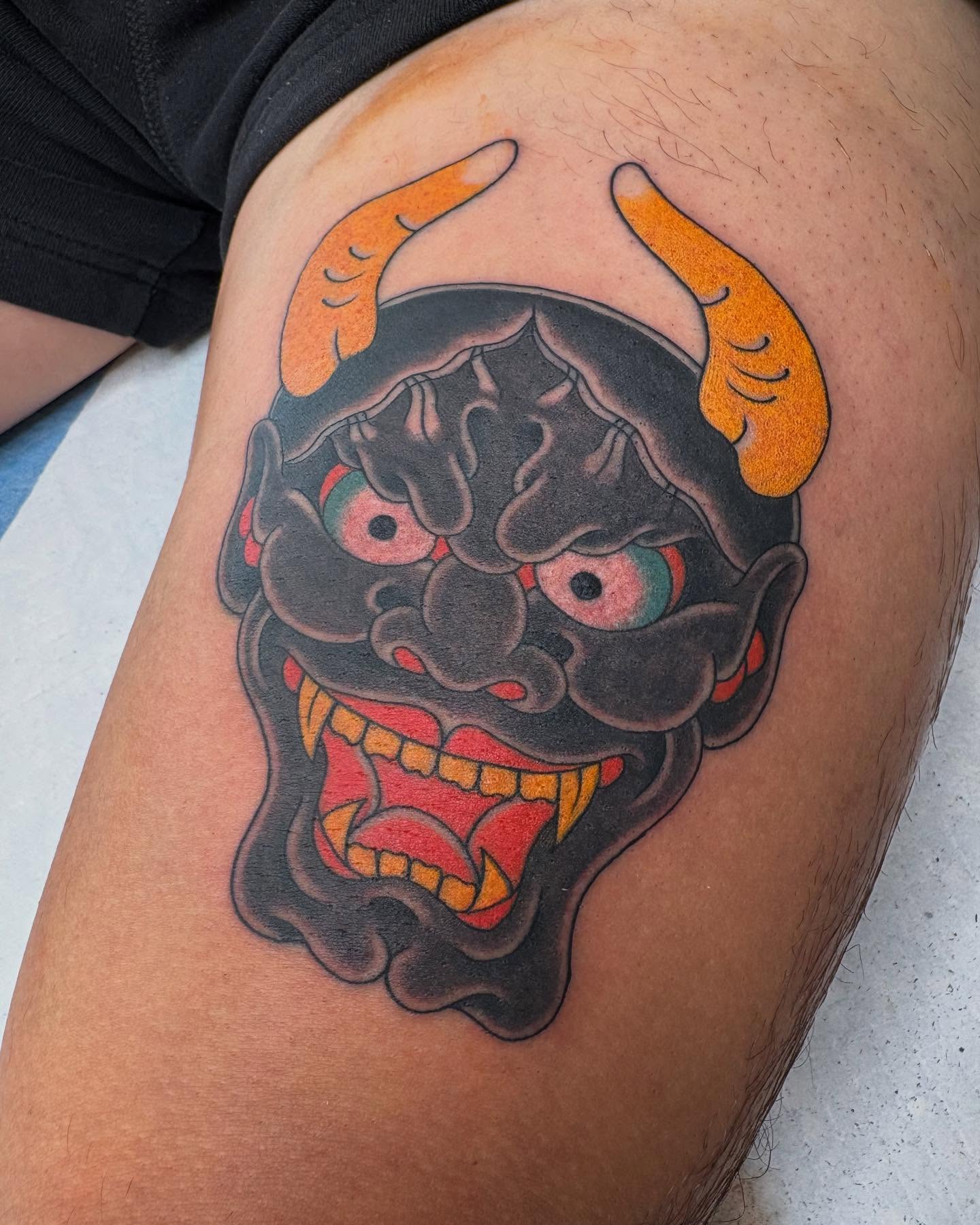 Demon mask American traditional tattoo on the thigh by Zach Hendrickson