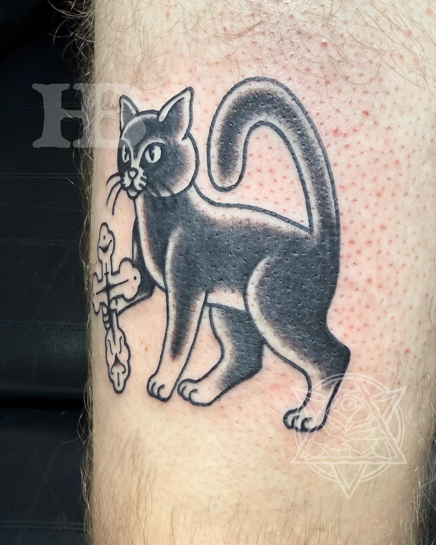 Cat and cross black and grey tattoo on the forearm by Hunter Beyer