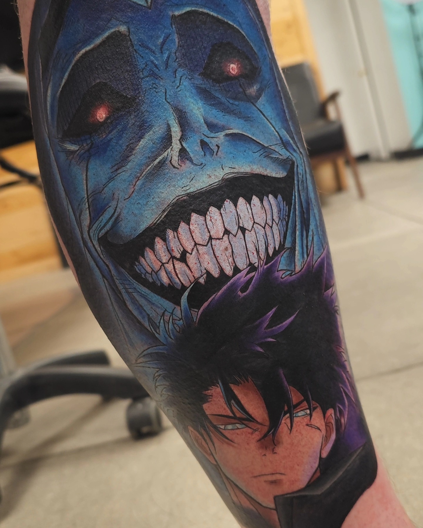Joker and anime character dark realism tattoo on the forearm by Devan Vankirk