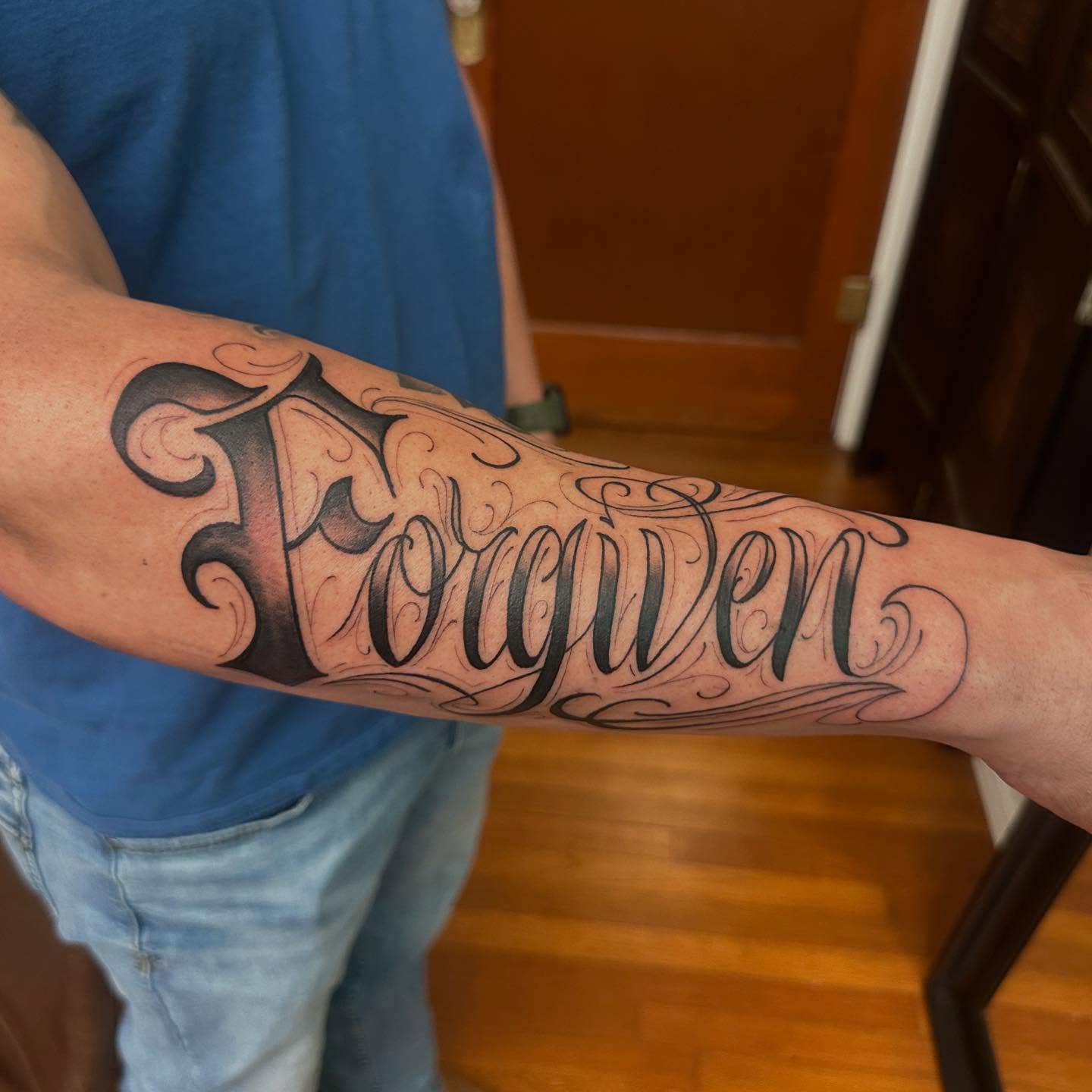 Forgiven lettering script tattoo on the forearm by Raul Najera Tattoo, Plano, Texas