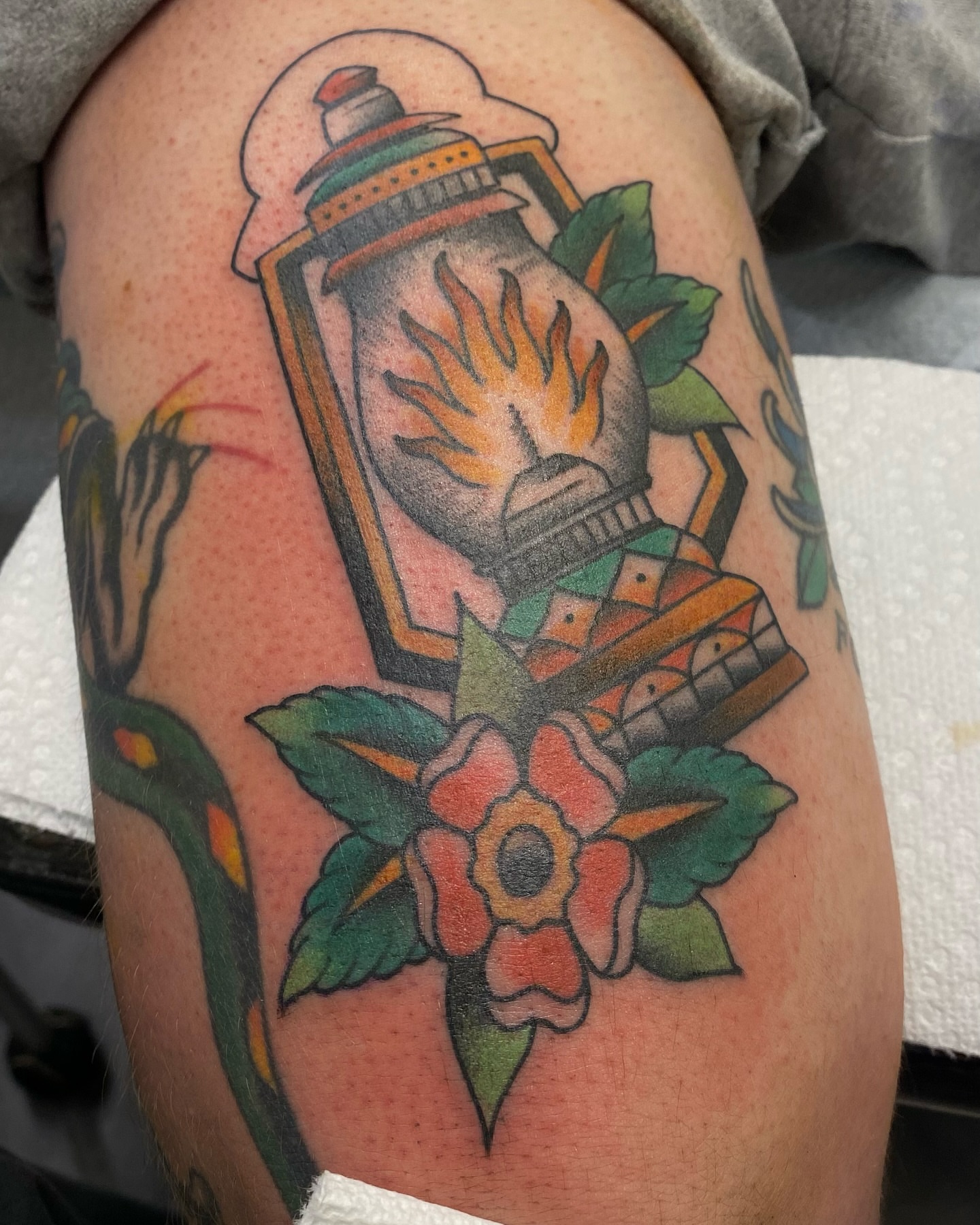 Lantern and flower American traditional tattoo on the thigh by Jesse Ortega