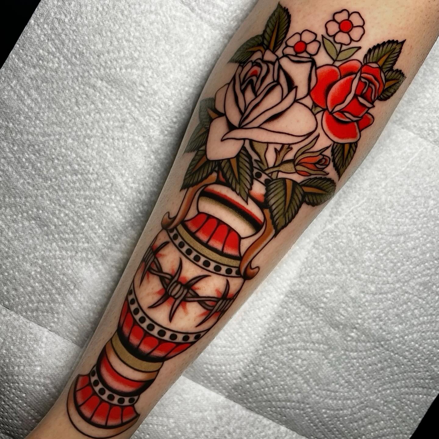 Barbed wire and roses American traditional tattoo on the forearm by Hailey Johnson
