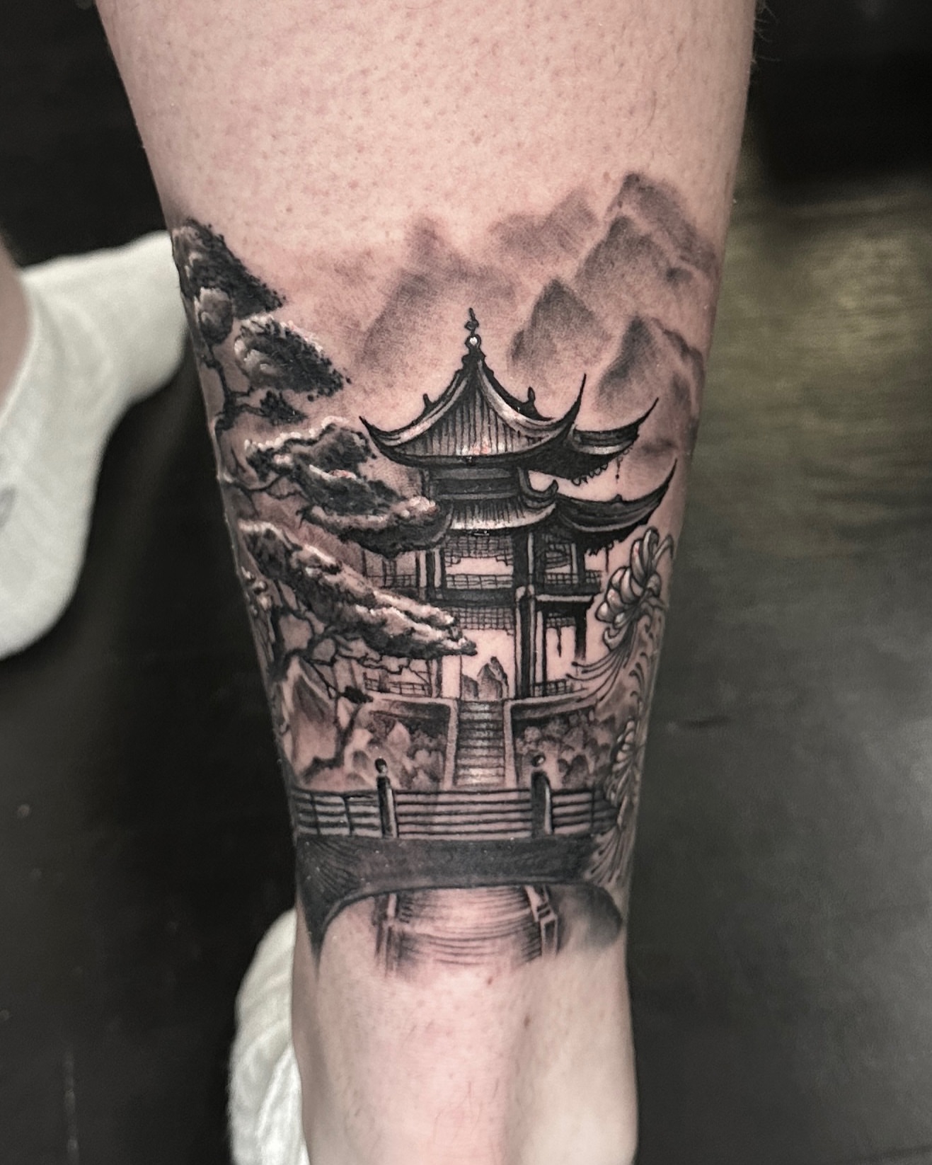 Oriental pagoda realism tattoo on the forearm by Madeleine Fleming
