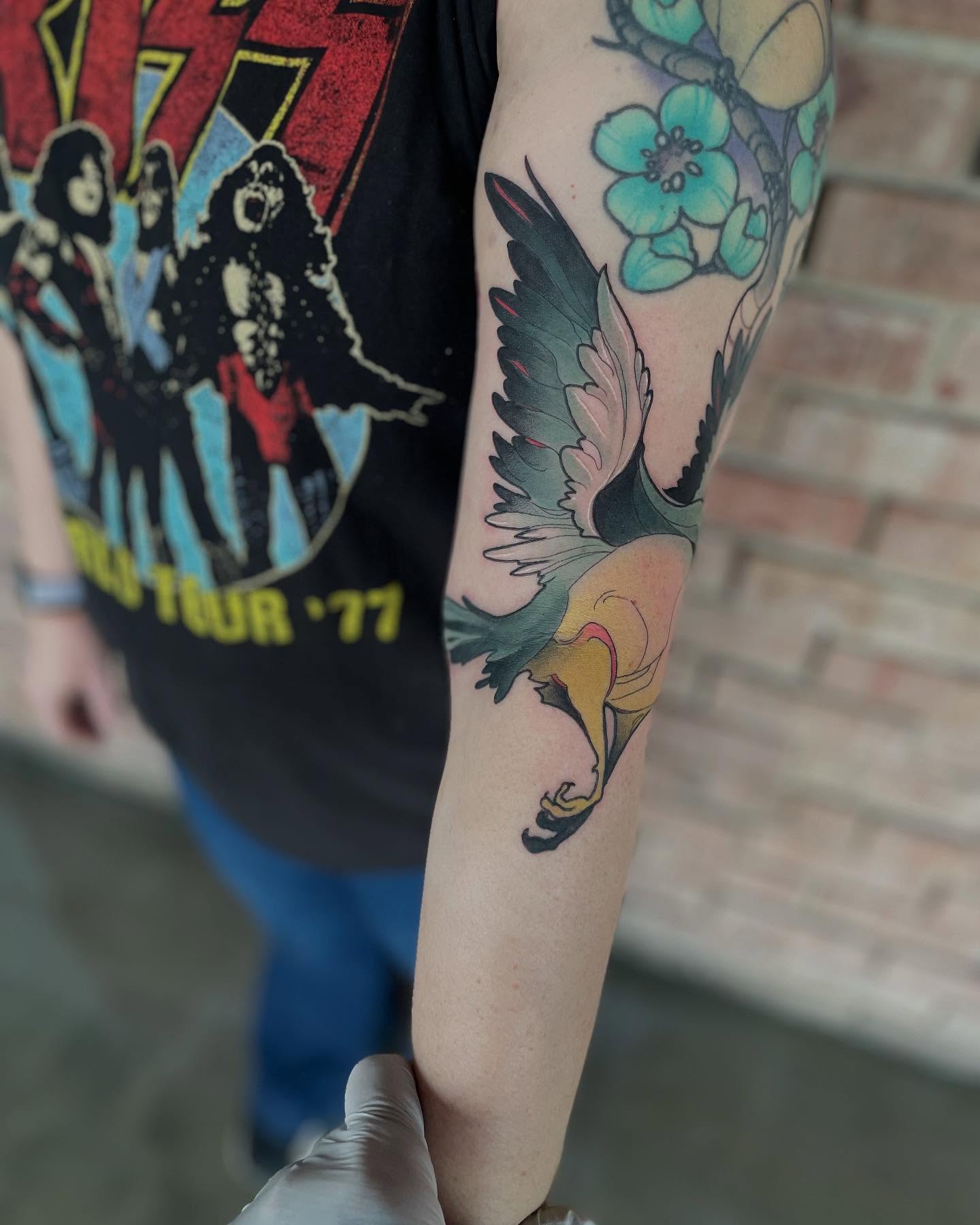 Bird and flowers American traditional tattoo on the forearm by Nathan Evans